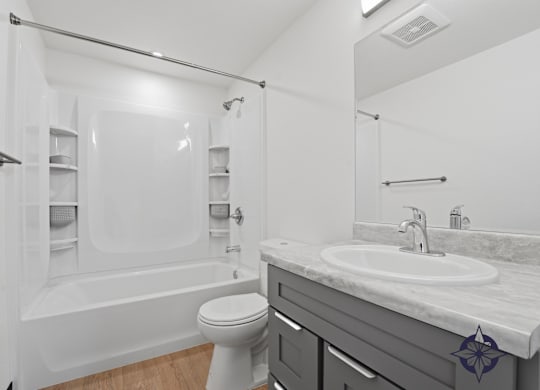 A white bathroom with a toilet, sink, and bathtub.