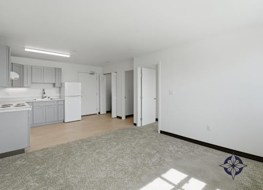 A kitchen with white appliances and a rug on the floor.