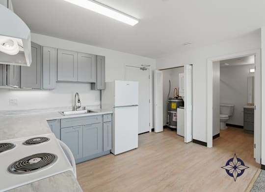A kitchen with a white fridge and a stove top.