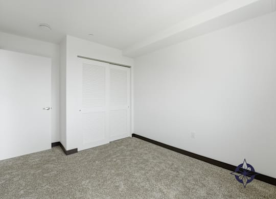 A room with a carpeted floor and a white door.