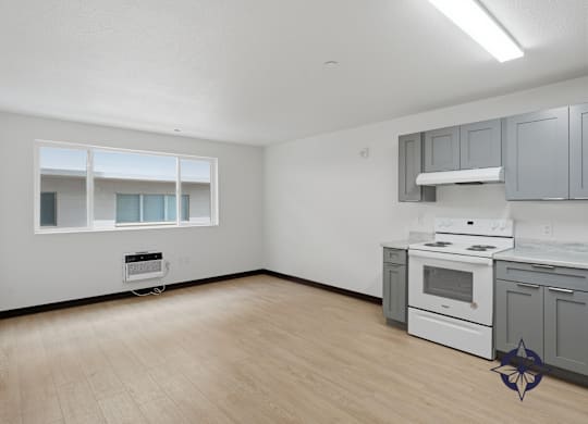 A kitchen with white appliances and wooden floors.
