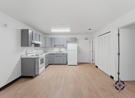 A kitchen with wooden floors and white walls.