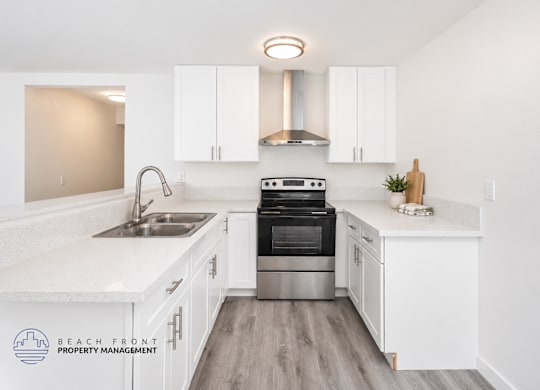 A kitchen with white cabinets and a stainless steel oven.