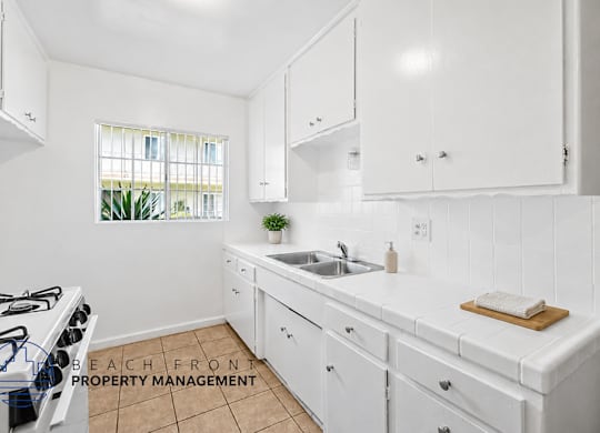A kitchen with white cabinets and a tiled backsplash.
