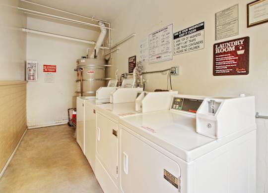 A laundry room with washers and dryers.