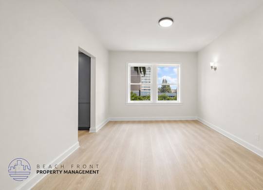 A spacious room with a view of the outside through a window.