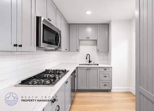 A kitchen with a stove top oven and a microwave above the stove.