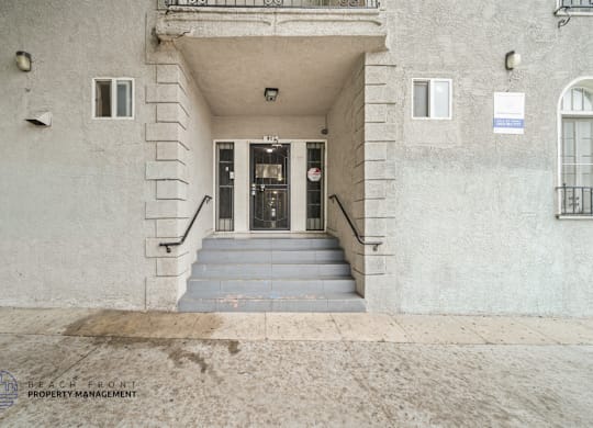 A building entrance with a sign for Beach Front Property Management.