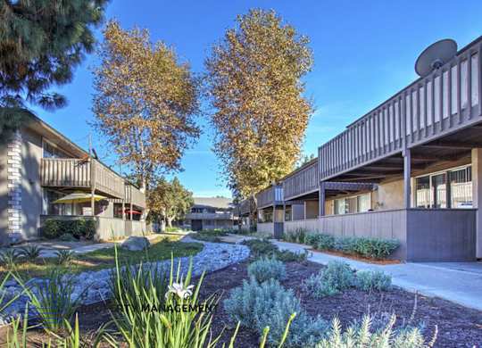 A row of modern buildings with trees in the background.