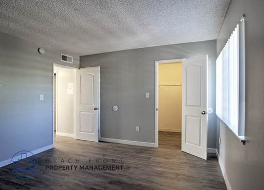 A room with a white door and a window on the right side.