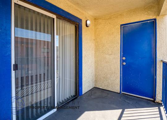 A blue door is on the right side of a window with a screen.