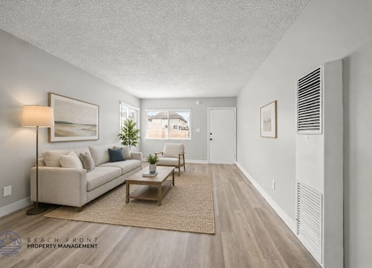 A living room with a couch, coffee table, and a window.