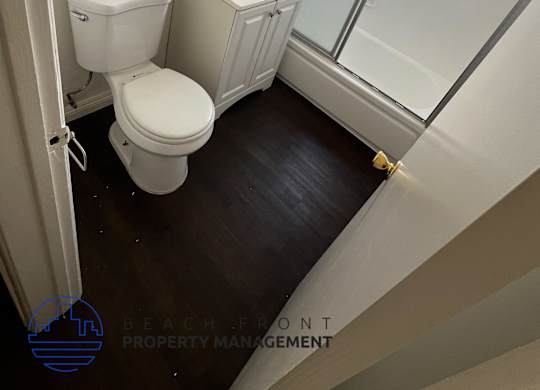A white toilet and sink in a small bathroom.