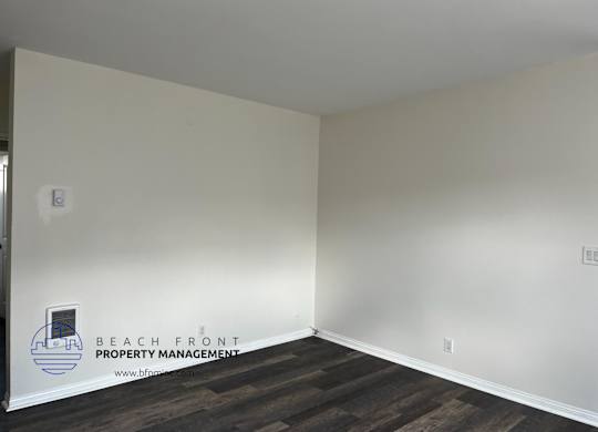 A room with a logo for Beach Front Property Management on the wall.