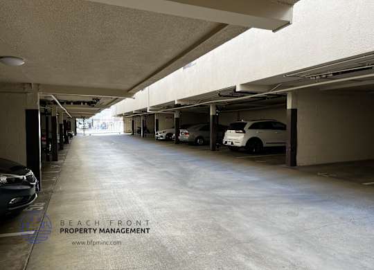 A parking garage with a sign that says Beach Front Property Management.