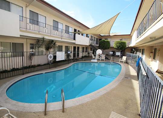 A small pool in a courtyard surrounded by buildings.