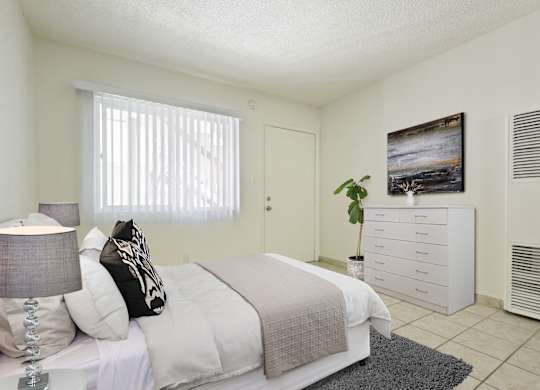A bedroom with a bed, nightstand, and a painting on the wall.