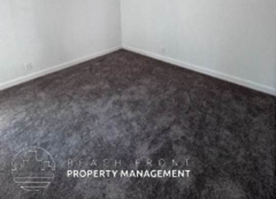 A room with a carpeted floor and white walls.