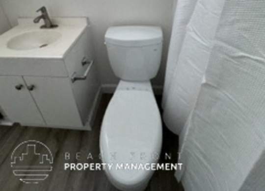 A white toilet sits next to a sink in a bathroom.