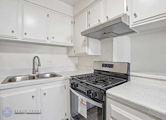 A modern kitchen with a stove top oven and a sink.