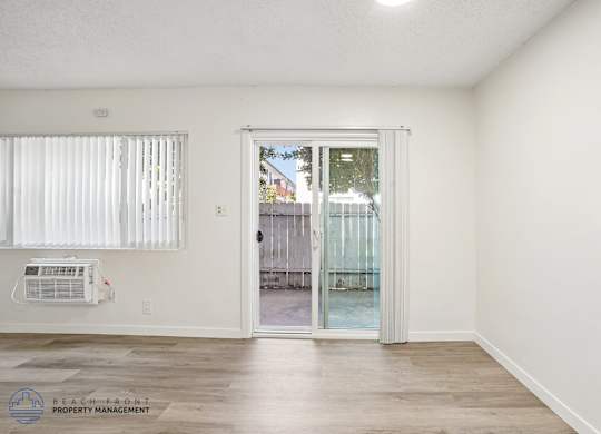 A room with a sliding glass door leading to a balcony.