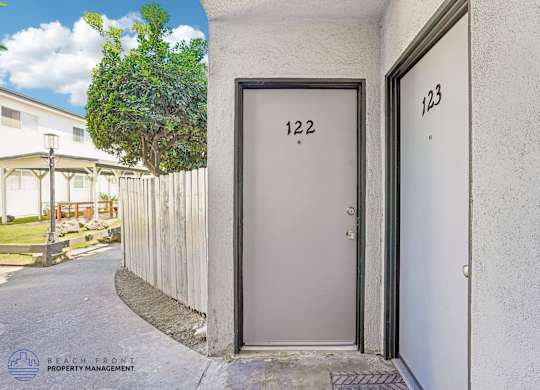 A grey door with the number 122 on it is closed.