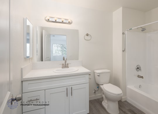 A white bathroom with a toilet, sink, and bathtub.