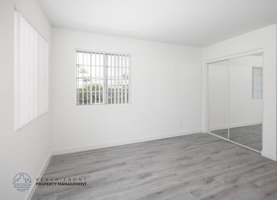 A room with a window and a door is empty and waiting to be furnished.