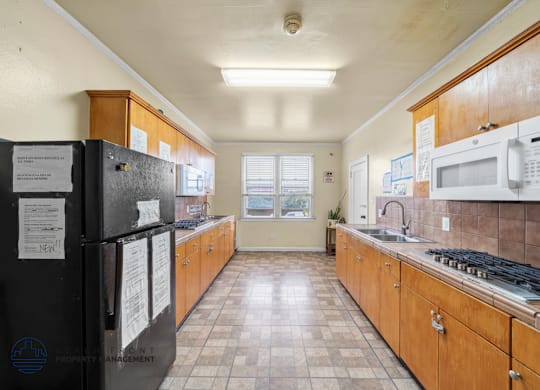 A kitchen with black appliances and wooden cabinets.