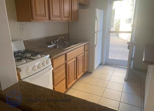 a kitchen with a stove and a sink and a refrigerator
