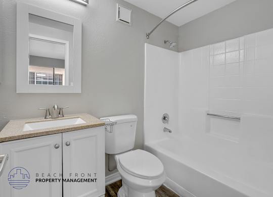 A white bathroom with a toilet, sink, and bathtub.