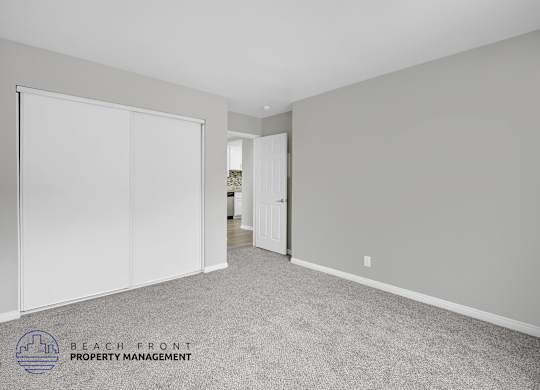 A room with a carpeted floor and a sliding door.