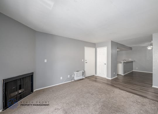 A spacious room with a fireplace and a carpeted floor.