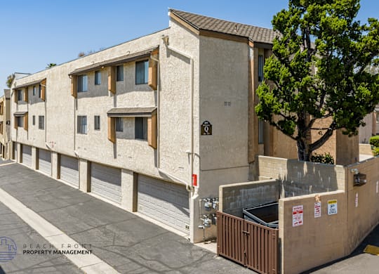 A concrete building with a tree in front of it.