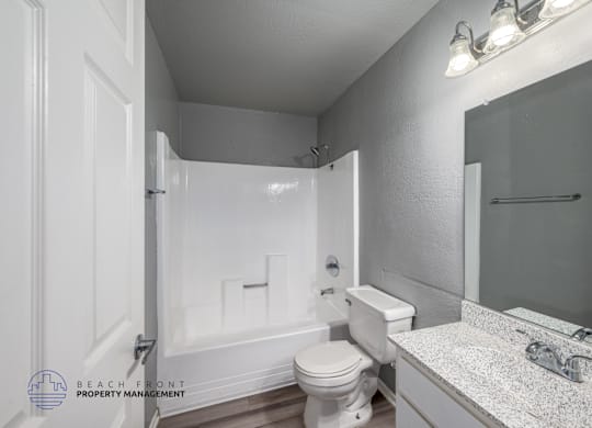 A bathroom with a toilet, sink, and bathtub.