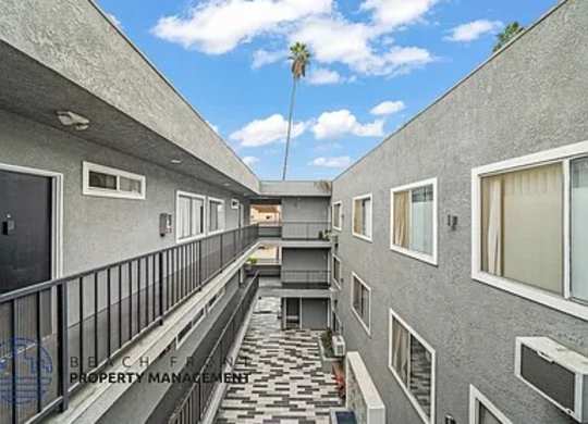 A balcony with a black railing and a tiled floor.