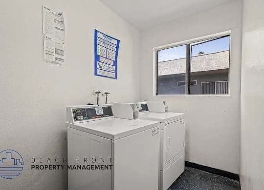 A white wall with a window and a sign that says Beach Front Property Management.