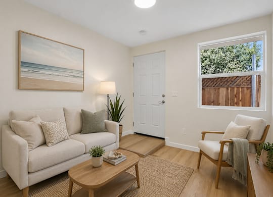 A living room with a couch, a chair, a coffee table, and a painting on the wall.