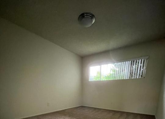 an empty room with carpet and a window