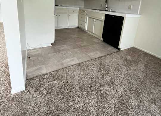A kitchen with white cabinets and a black dishwasher.