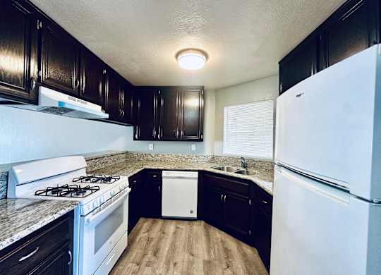 A kitchen with a white fridge and a white dishwasher.