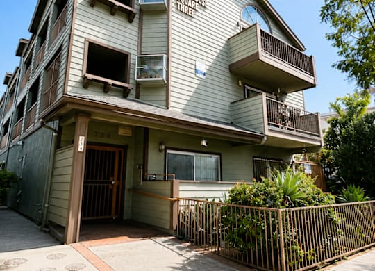 A two-story building with a balcony and a gate.