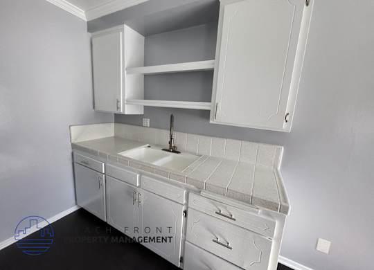 a small kitchen with white cabinets and a sink