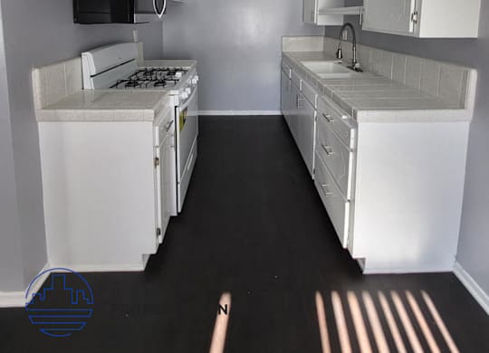 a kitchen with white cabinets and a stove and a sink