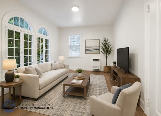 A living room with a couch, chair, and television.