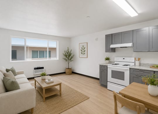 A living room with a couch, a table, and a kitchen area in the background.