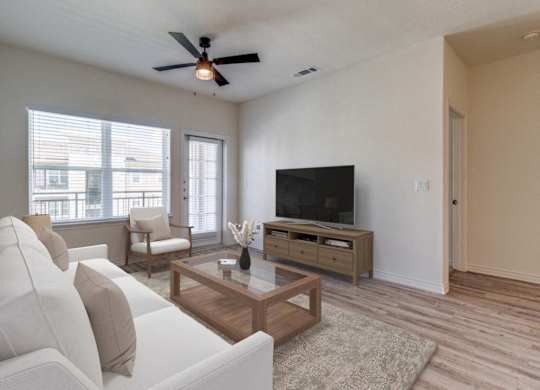 the living room of an apartment with a couch and a tv