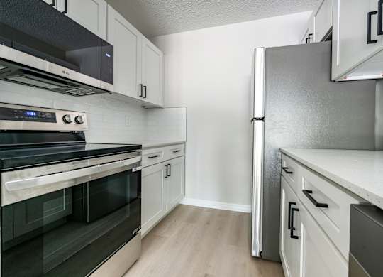A kitchen with a stove, oven, and refrigerator.