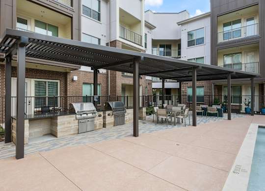 A patio area with a pool and a pergola.