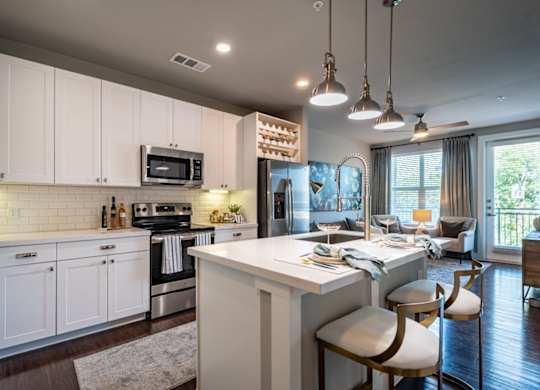 A modern kitchen with white cabinets and a large island.